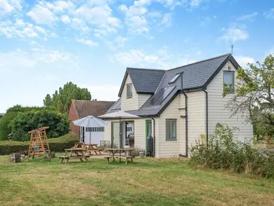 a house with a picnic table in the yard at Russets in North Weald