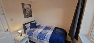 a small bedroom with a bed with a plaid blanket at Shirley L, Milton, Cambridge, 4 BR House, Newly Refurbished in Milton