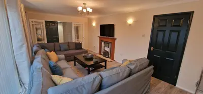 a living room with a large couch and a fireplace at Shirley L, Milton, Cambridge, 4 BR House, Newly Refurbished in Milton
