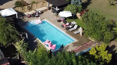 an overhead view of a swimming pool with umbrellas at Farmhouse Retreat with Hot Tub, Pool, Horses, Games Room, Free Car Park, Only 45 min from Oxford Circus in Stapleford Tawney