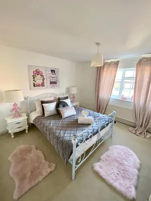a bedroom with a bed and two rugs at Farmhouse Retreat with Hot Tub, Pool, Horses, Games Room, Free Car Park, Only 45 min from Oxford Circus in Stapleford Tawney