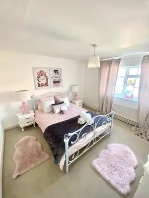 a bedroom with a bed and two rugs at Farmhouse Retreat with Hot Tub, Pool, Horses, Games Room, Free Car Park, Only 45 min from Oxford Circus in Stapleford Tawney