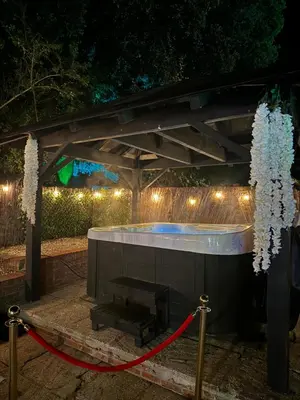 a hot tub under a pergola with lights at Farmhouse Retreat with Hot Tub, Pool, Horses, Games Room, Free Car Park, Only 45 min from Oxford Circus in Stapleford Tawney