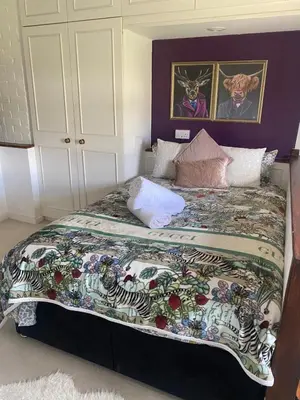 a bedroom with a bed with a zebra blanket at Farmhouse Retreat with Hot Tub, Pool, Horses, Games Room, Free Car Park, Only 45 min from Oxford Circus in Stapleford Tawney