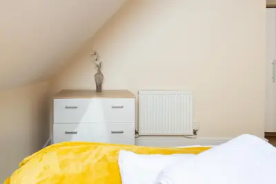a bedroom with a bed and a white dresser at Velvet 1-bedroom penthouse, Clockhouse, Hoddesdon in Hoddesdon