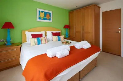 a bedroom with a large bed with towels on it at 252 Aldeburgh Townhouse - Aldeburgh Coastal Cottages in Aldeburgh