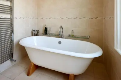 a white bath tub in a bathroom with a shower at 252 Aldeburgh Townhouse - Aldeburgh Coastal Cottages in Aldeburgh