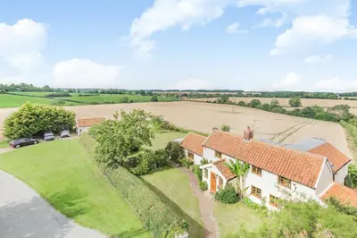 an aerial view of a house with a field at Skelder, Parham in Parham