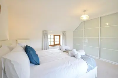 a bedroom with a large white bed with blue pillows at Skelder, Parham in Parham