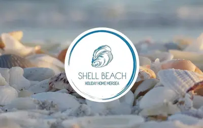 a sign on a pile of shells on a beach at Shell Beach Holiday Home Mersea Coopers Beach in East Mersea