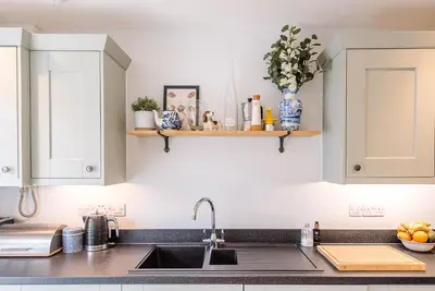 a kitchen with white cabinets and a sink at Martlet Cottage Aldeburgh in Aldeburgh