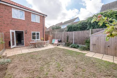 a backyard with a wooden fence and a patio at Martlet Cottage Aldeburgh in Aldeburgh