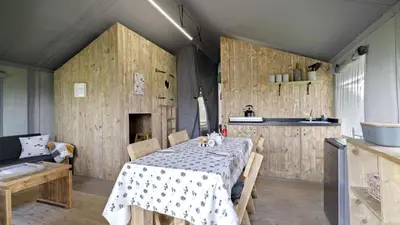a dining room with a table and a kitchen at Finest Retreats - The Herdwick Safari Tent in Hertford