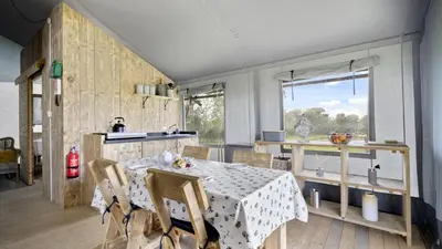 a dining room with a table and a window at Finest Retreats - The Herdwick Safari Tent in Hertford