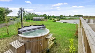 a hot tub in the middle of a yard at Finest Retreats - The Highland Camping Pod in Hertford