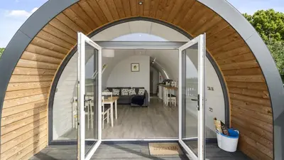 an arched entrance to a tiny house with a dining room at Finest Retreats - The Highland Camping Pod in Hertford
