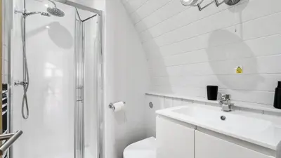 a white bathroom with a shower and a sink at Finest Retreats - The Chicken Coop in Hertford
