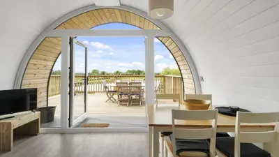 a living room with an arched window and a dining table at Finest Retreats - The Chicken Coop in Hertford