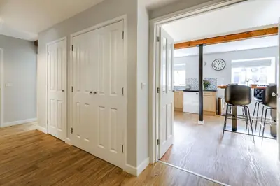 an open hallway with white doors and a dining room at The Old Warehouse Ely in Ely