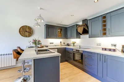 a large kitchen with blue cabinets and a counter at The Old Warehouse Ely in Ely