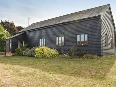 a black house with a yard in front of it at Leys Barn in Great Chishall