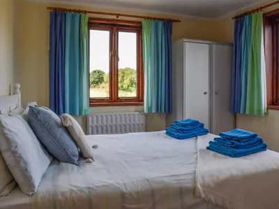 a bedroom with a bed with blue towels on it at Leys Barn in Great Chishall
