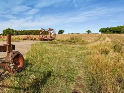 an old tractor sitting in the middle of a field at Leys Barn in Great Chishall