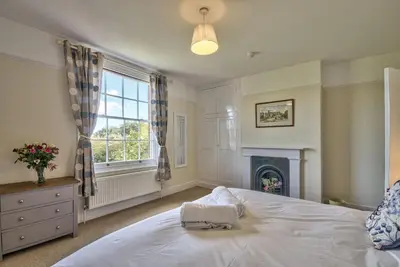 a bedroom with a white bed and a fireplace at Harkstead Hall By Group Retreats in Ipswich