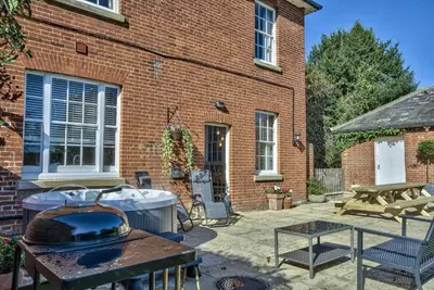 a backyard with a grill and a brick building at Harkstead Hall By Group Retreats in Ipswich