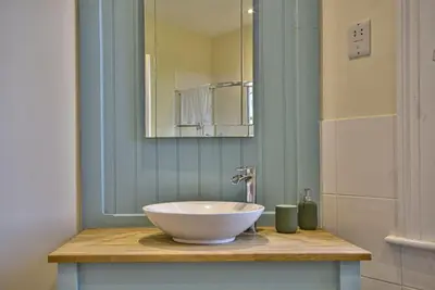 a bathroom with a bowl sink and a mirror at Harkstead Hall By Group Retreats in Ipswich