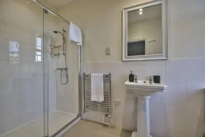 a bathroom with a shower and a sink and a mirror at Harkstead Hall By Group Retreats in Ipswich