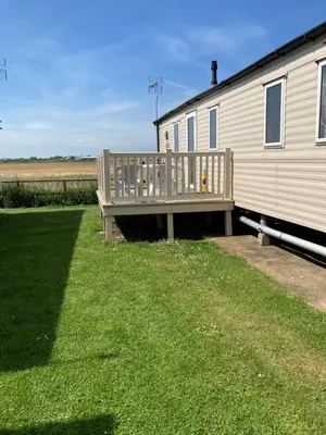 a wooden bench sitting next to a trailer at Luxury 8 and 6 berth caravans in Jaywick Sands