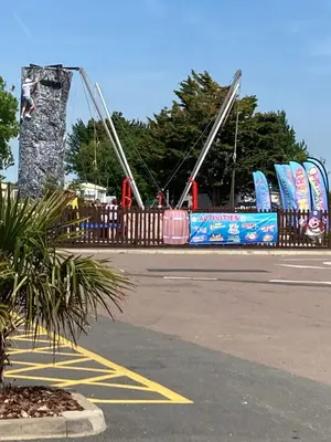 a playground with a roller coaster in a parking lot at Luxury 8 and 6 berth caravans in Jaywick Sands