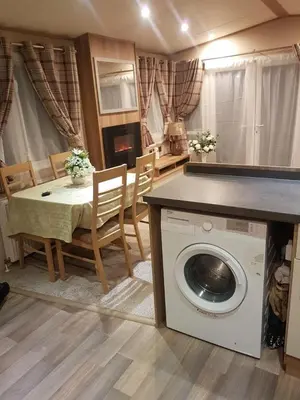 a living room with a table and a washing machine at Luxury 8 and 6 berth caravans in Jaywick Sands