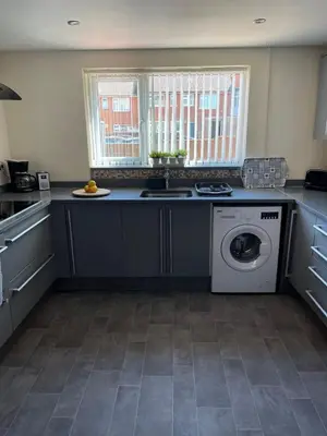 a kitchen with a sink and a washing machine at Sea Breeze in Harwich
