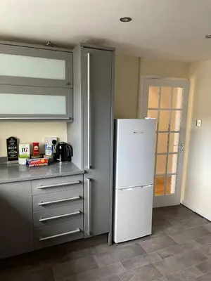 a kitchen with a white refrigerator in a room at Sea Breeze in Harwich