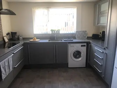 a kitchen with a washing machine and a window at Sea Breeze in Harwich