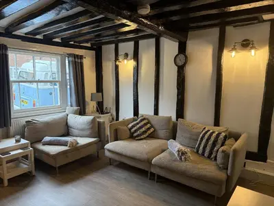 a living room with two couches and a clock at Tidal Walk in Harwich