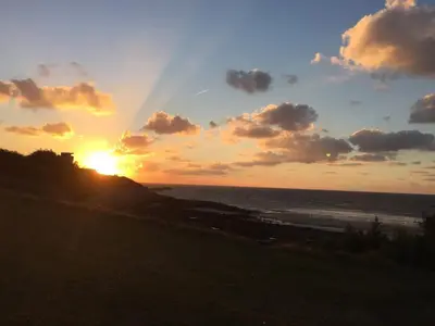 a sunset over the ocean with the sun setting at Tidal Walk in Harwich