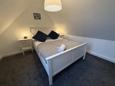 a bedroom with a white bed with black pillows at Tidal Walk in Harwich