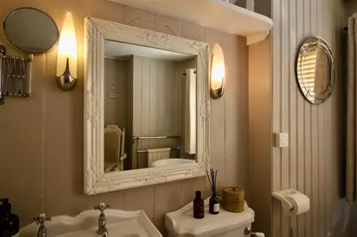 a bathroom with a mirror and a white sink at The Cottage at Barkwith House in Leiston