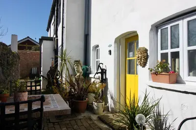 a patio with plants and a yellow door at The Cottage at Barkwith House in Leiston