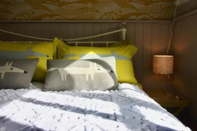 a bedroom with a bed with yellow and blue pillows at The Cottage at Barkwith House in Leiston