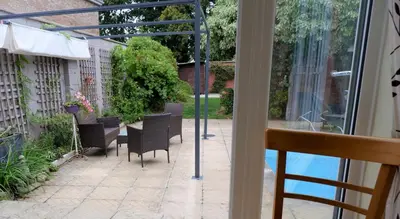 a view of a patio with chairs and a table at Colchester Sunny Apartment with Pool and EV Car Point in Lexden