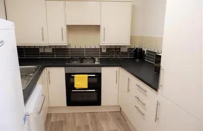 a kitchen with white cabinets and an oven at Colchester Sunny Apartment with Pool and EV Car Point in Lexden