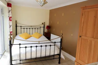 a bedroom with a bed with yellow pillows on it at Colchester Sunny Apartment with Pool and EV Car Point in Lexden