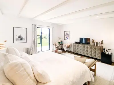 a white bedroom with a large bed and a window at Little Owl by The Suffolk Cottage Collection in Aldeburgh
