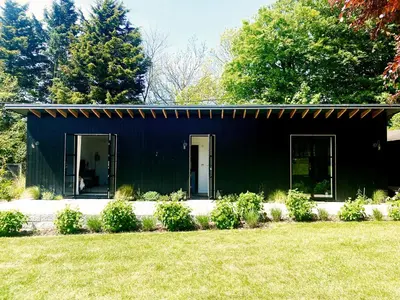 a black house with a green at Little Owl by The Suffolk Cottage Collection in Aldeburgh