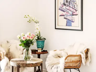 a living room with a couch and a table with flowers at Little Owl by The Suffolk Cottage Collection in Aldeburgh