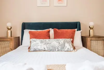 a bedroom with a bed with orange and white pillows at Guildhall Street Apartment, Bury St Edmunds in Bury Saint Edmunds